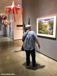Mom admiring a painting at the exhibit.