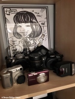 Some of my cameras...I'm a Canon girl but I did venture into Nikon territory a while back! The caricaure was made at an event I went to.